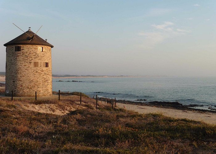 Le vieux moulin de la plage pointé en direction de la mer bleue